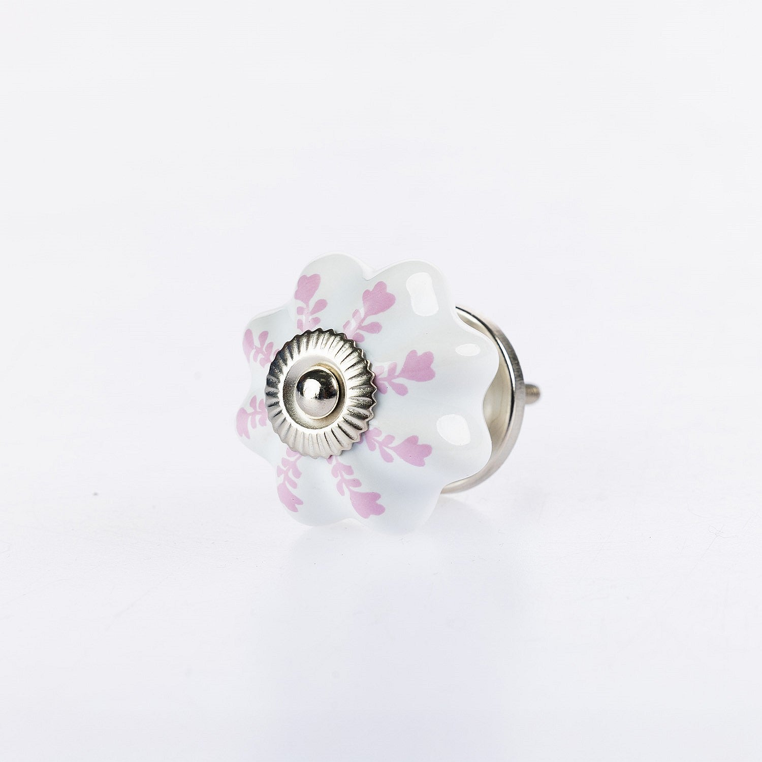 White flower-shaped ceramic drawer knob with soft pink leaf detailing and silver metal centre accent.
