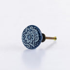 Blue ceramic round drawer knob with embossed floral pattern detailing and metal screw fitting.
