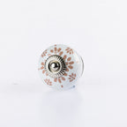 White ceramic round drawer knob with Almond floral lace pattern detailing and silver metal centre accent.