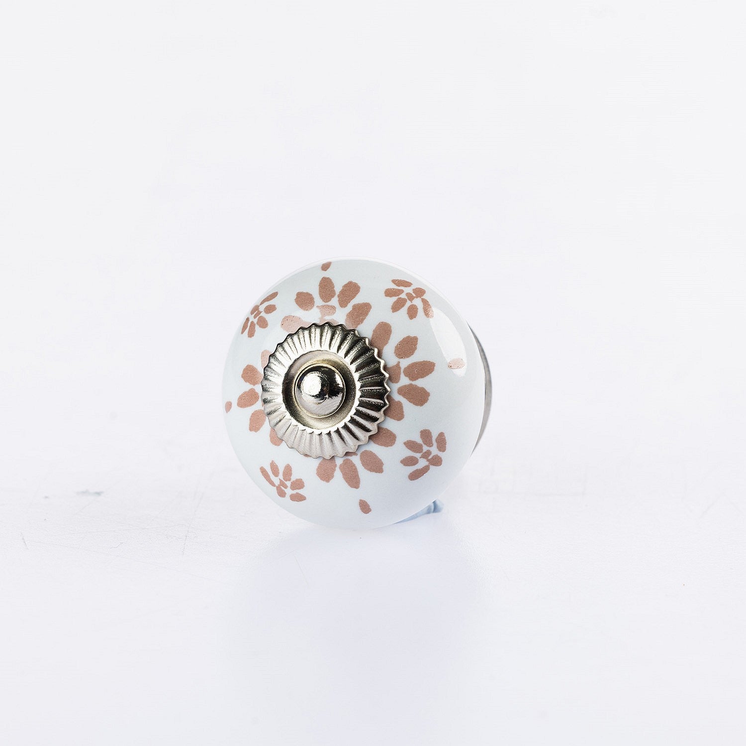 White ceramic round drawer knob with Almond floral lace pattern detailing and silver metal centre accent.