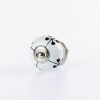 White ceramic round drawer knob with black berry vine pattern and silver metal centre accent.
