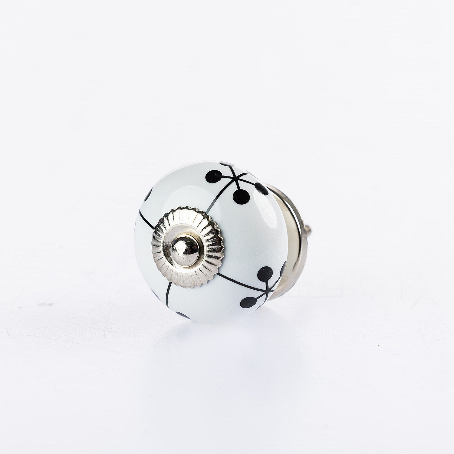 White ceramic round drawer knob with black berry vine pattern and silver metal centre accent.

