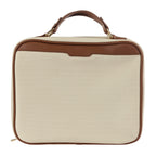 Neutral canvas vanity case with brown trim detailing, carry handle, and gold hardware on a white background.

