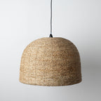 Woven pendant light on a plain background