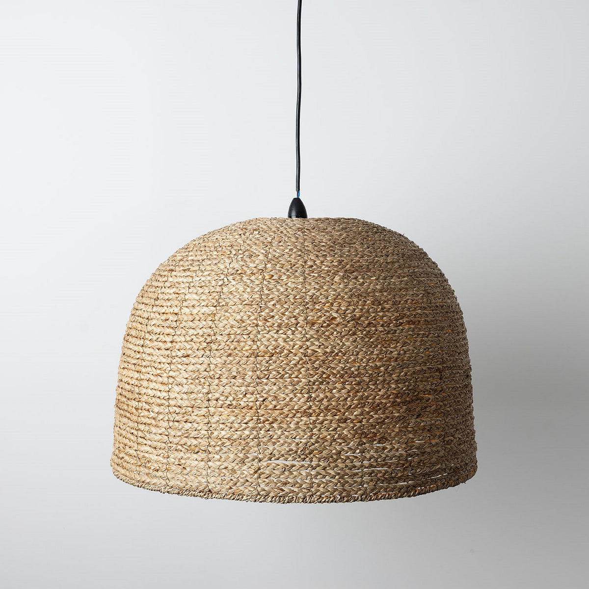 Woven pendant light on a plain background