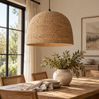 Close-up of a woven natural fiber lampshade, showing the textured seagrass or straw material in a light tan color, with a dark interior and a light metal shade support visible.