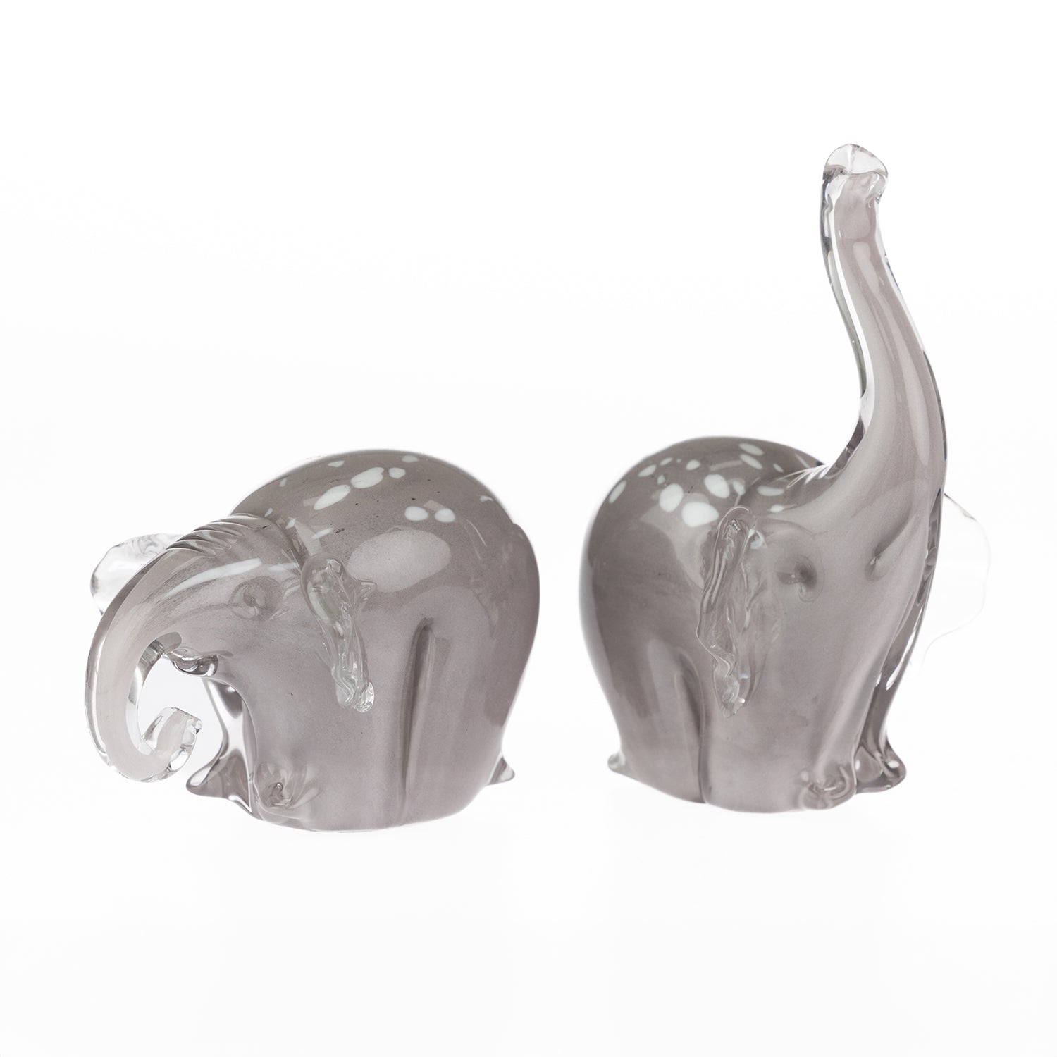Pair of smoke grey hand-blown glass elephant figurines with white spotted detailing, shown from different angles against a white background.