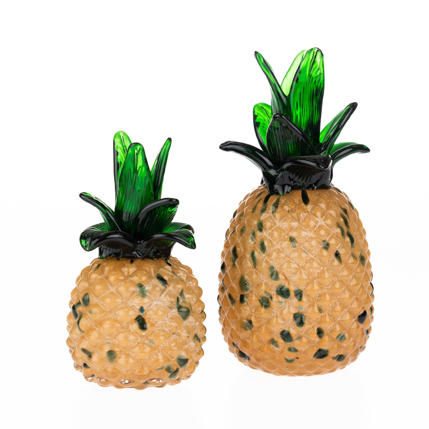 Small and large decorative glass pineapple ornaments with textured amber-coloured bodies and translucent green leaves displayed against a light grey background.