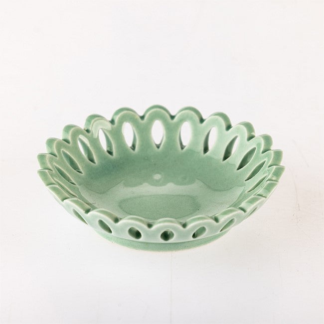 A small ceramic bowl with a scalloped, openwork edge and a glossy light green glaze, photographed on a plain white background.