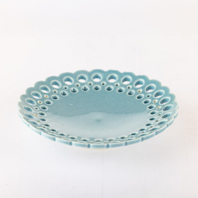 A small round ceramic dish with a scalloped edge and perforated cutouts around the rim, shown on a plain white background.