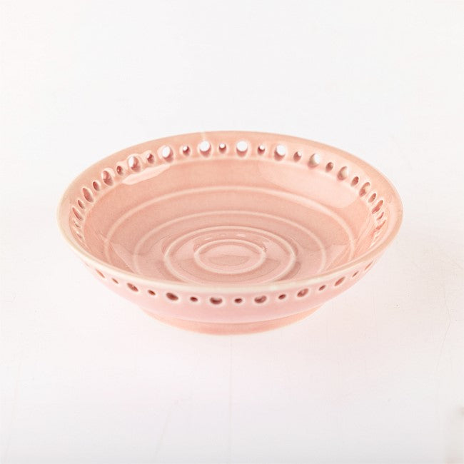 A light pink ceramic bowl with a decorative perforated rim and concentric ring patterns inside, shown on a plain white background.