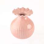 A small glossy pink ceramic vase with a fluted, scalloped rim and vertical ribbed texture, shown on a plain white background.