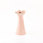 A small pale pink ceramic flower-shaped candle holder with a fluted neck and a single central opening, shown on a plain white background.