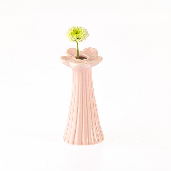 A light pink ceramic vase with a fluted, ribbed body and a flower-shaped rim, holding a single pale yellow-green daisy on a white background.