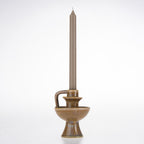Brown ceramic candle holder with a rounded bowl-shaped base, pedestal foot and curved handle, styled with a taupe taper candle.