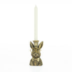 Decorative rabbit candleholder with gold glasses, bow tie, and crown holding a white tapered candle.