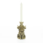 Decorative highland cow candleholder with gold glasses, bow tie, and crown holding a white tapered candle.