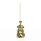 Decorative monkey candleholder with gold glasses, bow tie, and crown holding a white tapered candle.