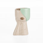 Speckled ceramic head vase with soft green glazed detail on a white background.
