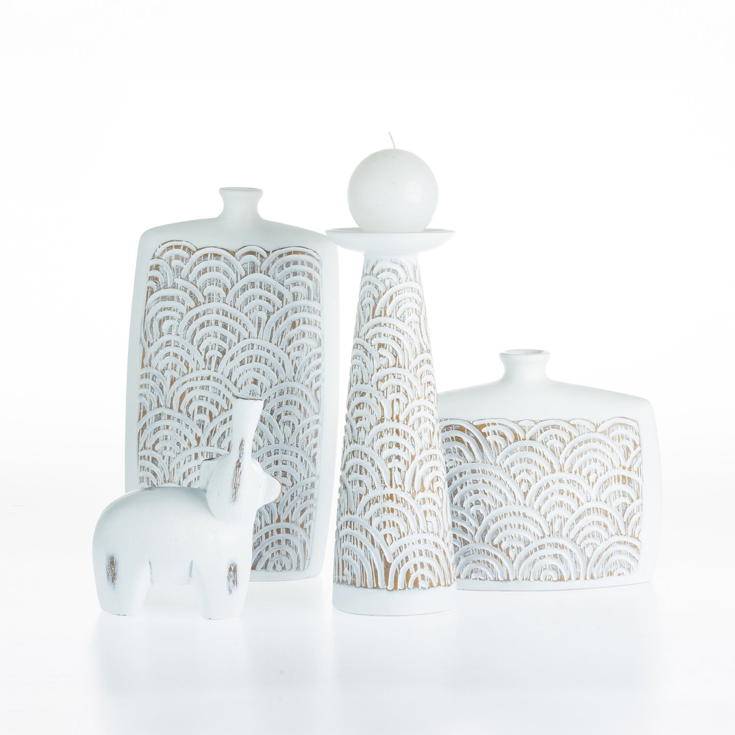 Cove Malaya décor pieces styled together, including the large urn, candle holder, decorative bottle, and elephant ornament in coordinating white textured finishes with carved arch detailing.