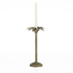 Pewter palm tree candle holder with a tall ivory tapered candle on a white background.