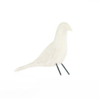 White decorative bird ornament with black metal legs on a white background.