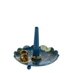 Blue floral trinket tray with gold jewellery displayed around the central ring holder on a white background.