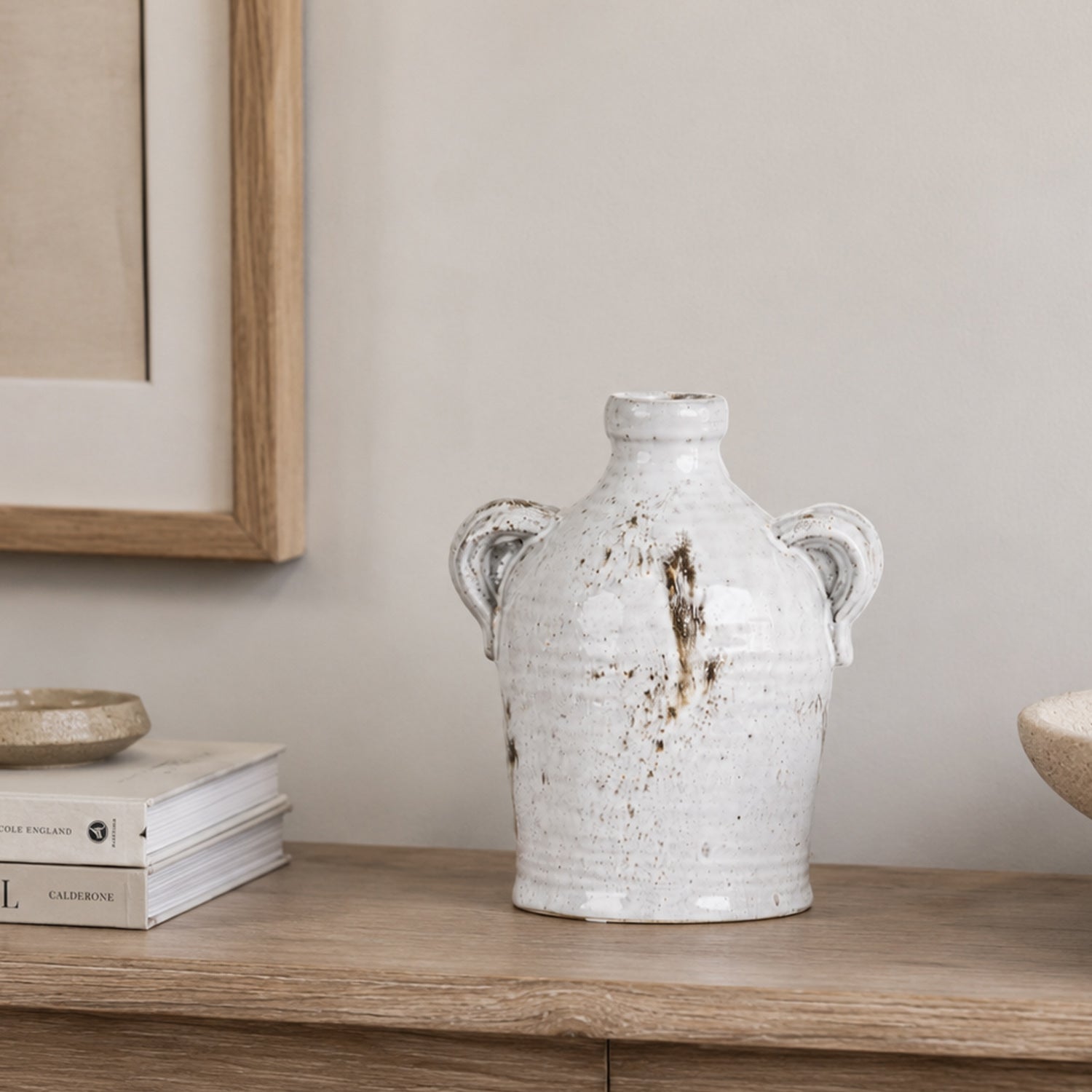 Large Cove Franco Ceramic Ears Vase displayed on a wooden console beside stacked books and decorative accents.