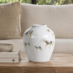 Large reactive glaze ceramic vase displayed on a wooden coffee table beside stacked books and a decorative bowl in a bright living room.