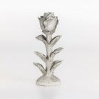 Large flower-shaped candle holder with a white taper candle on a white background.