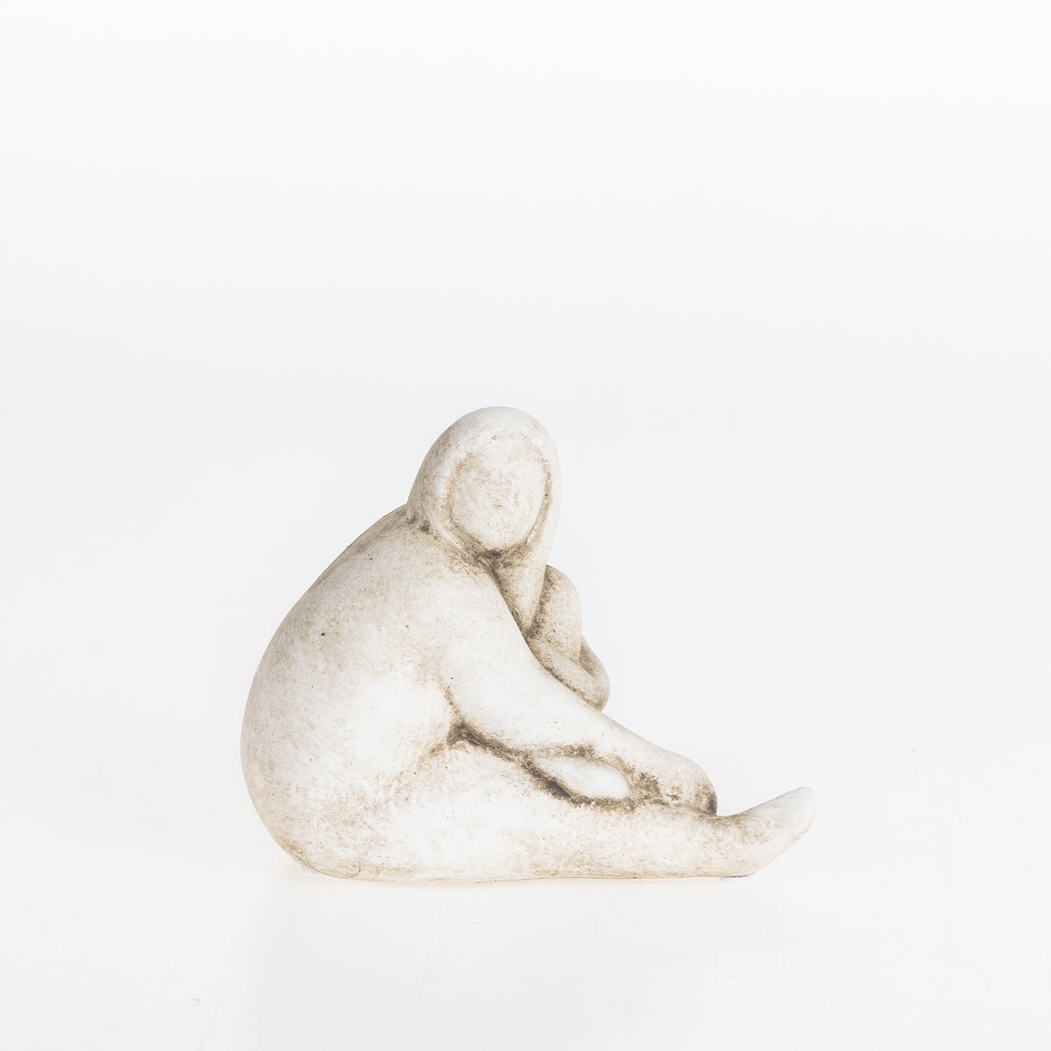Abstract ceramic lady resting figurine in a natural stone-look finish on a white background.