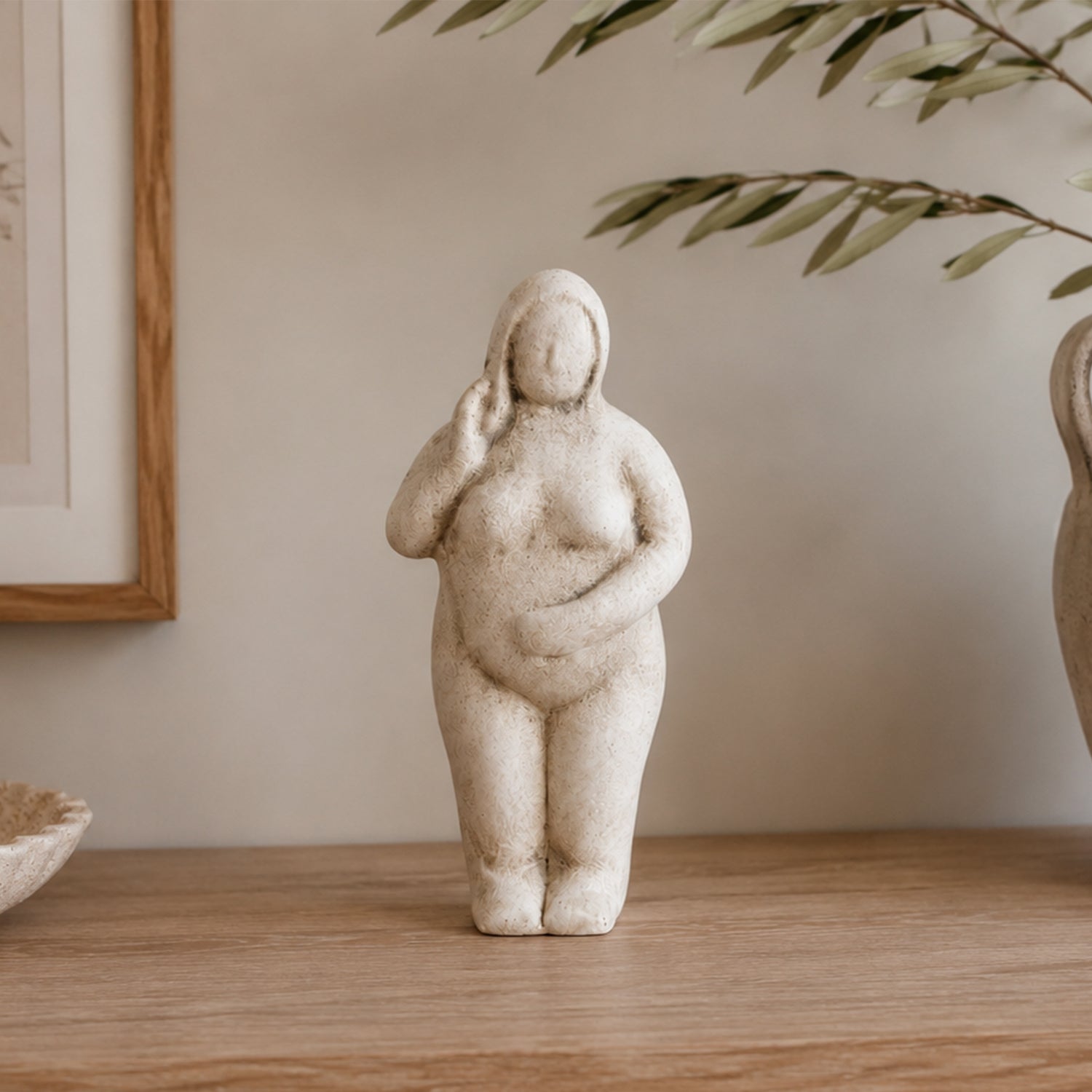 Cove Franco ceramic lady figurine displayed on a wooden console with olive branches and neutral décor in a warm, contemporary interior.