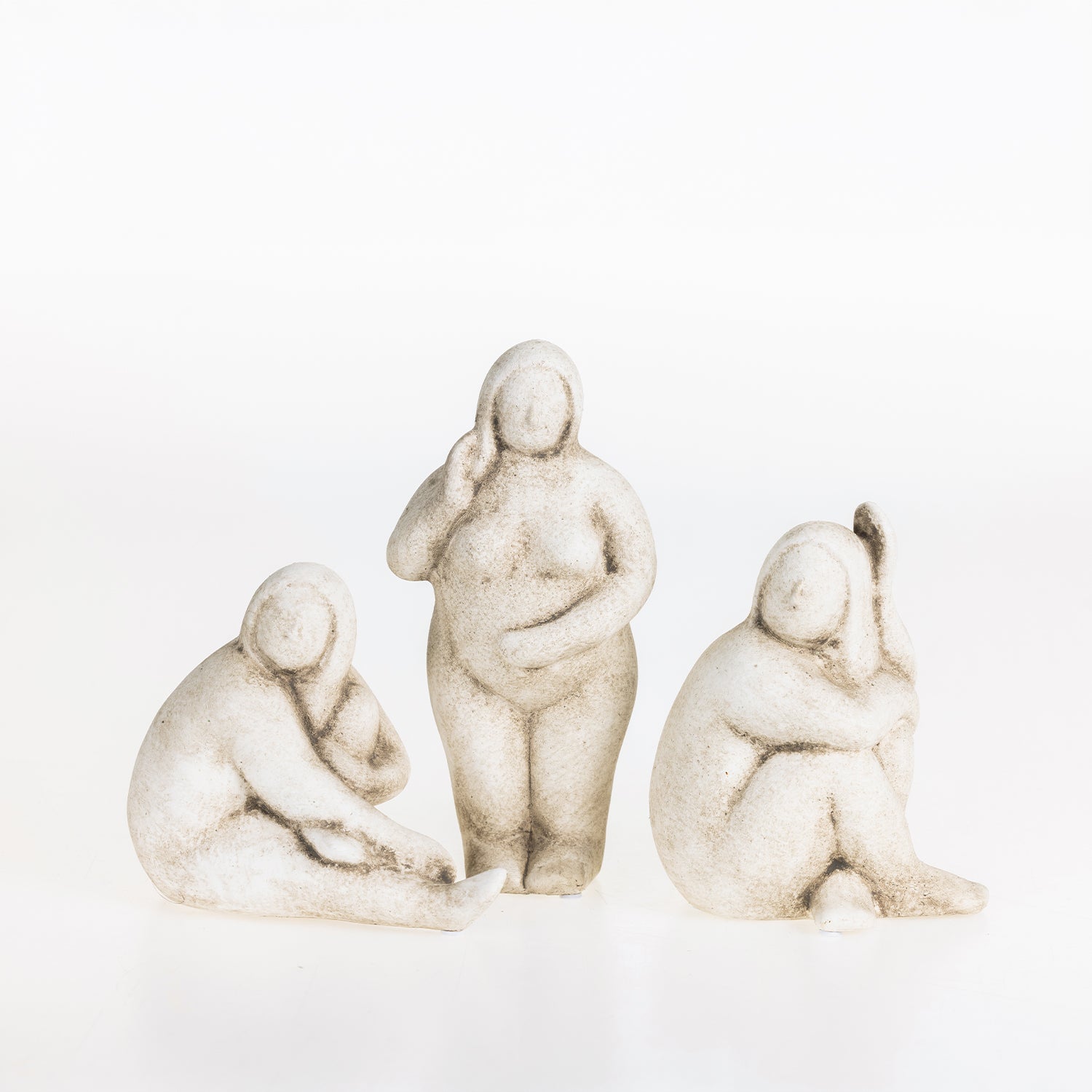 Three abstract ceramic lady figurines in natural stone-look finishes displayed together on a white background.