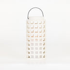 White ceramic lantern with a square cut-out design, black metal carry handle and a lit candle inside, shown on a white background.