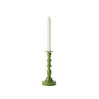 Green decorative candle holder displayed with a tall white taper candle against a white background.