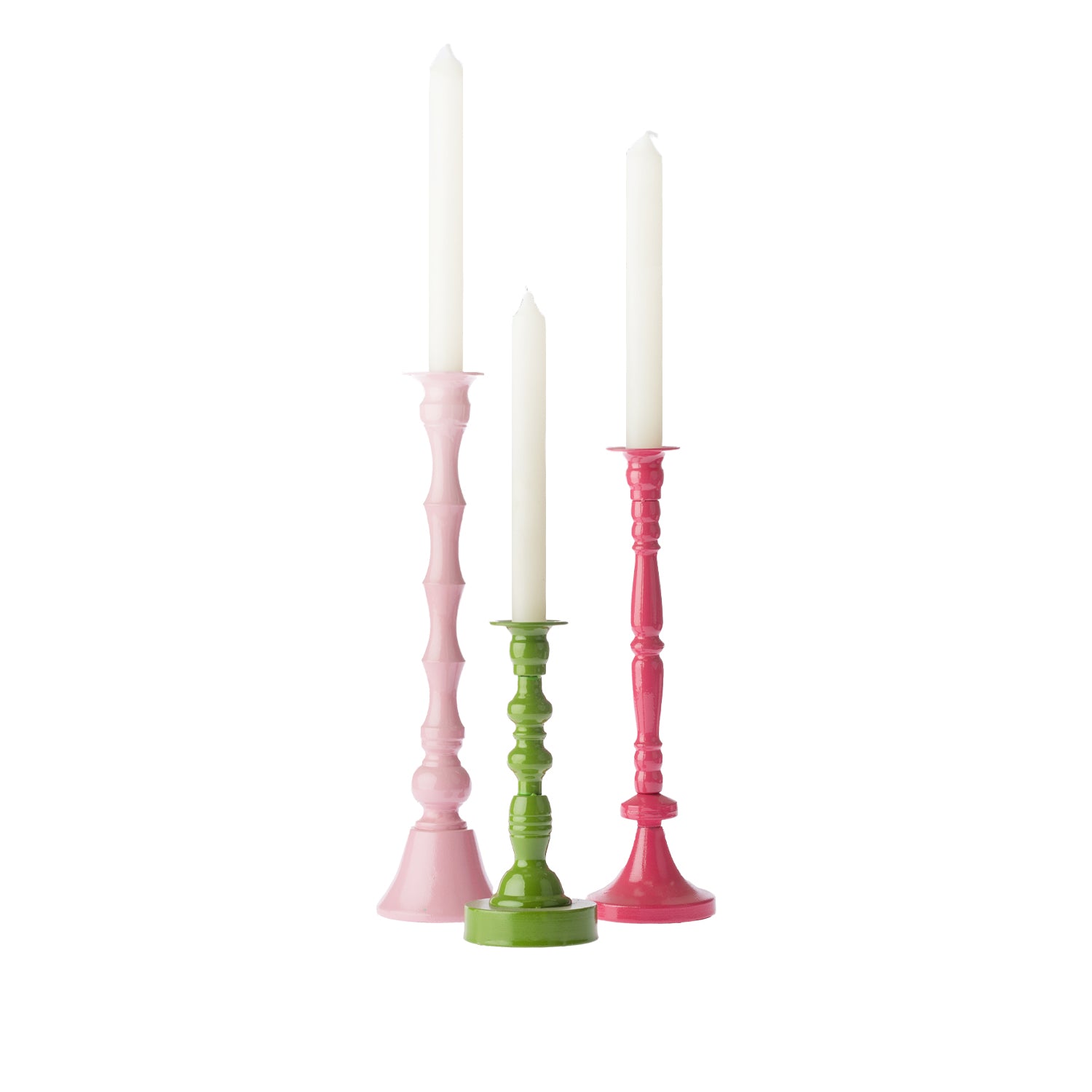 Three decorative candle holders in blush pink, green and fuchsia, each displayed with a white taper candle and arranged together against a white background.