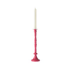 Fuchsia decorative candle holder displayed with a tall white taper candle against a white background.