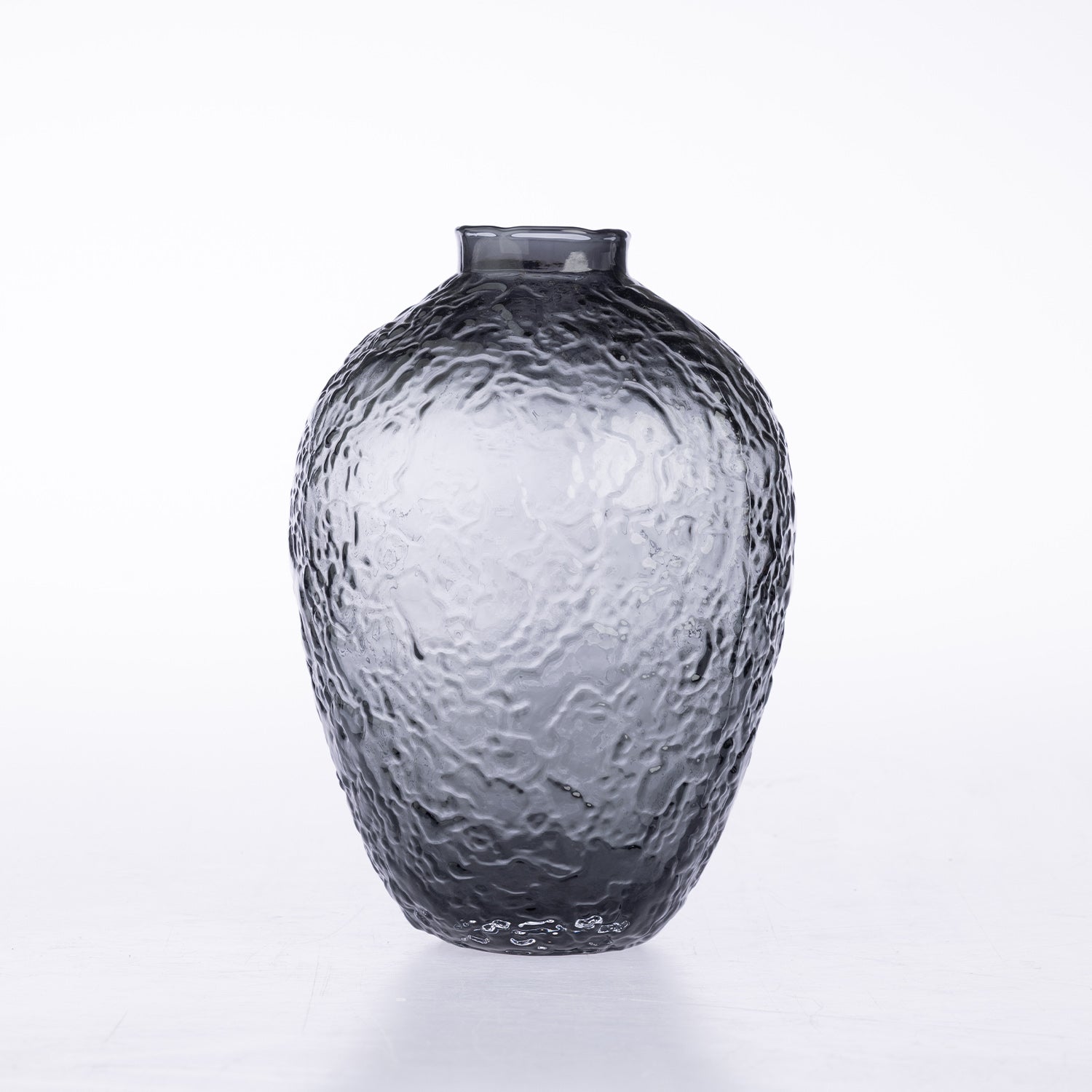 A textured dark gray glass vase with a short neck and rounded body, featuring a hammered or dimpled surface pattern, set against a plain white background.
