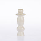 A small glossy ceramic candle holder with a bulbous, tiered design in a warm cream or off-white glaze, set against a plain white background.