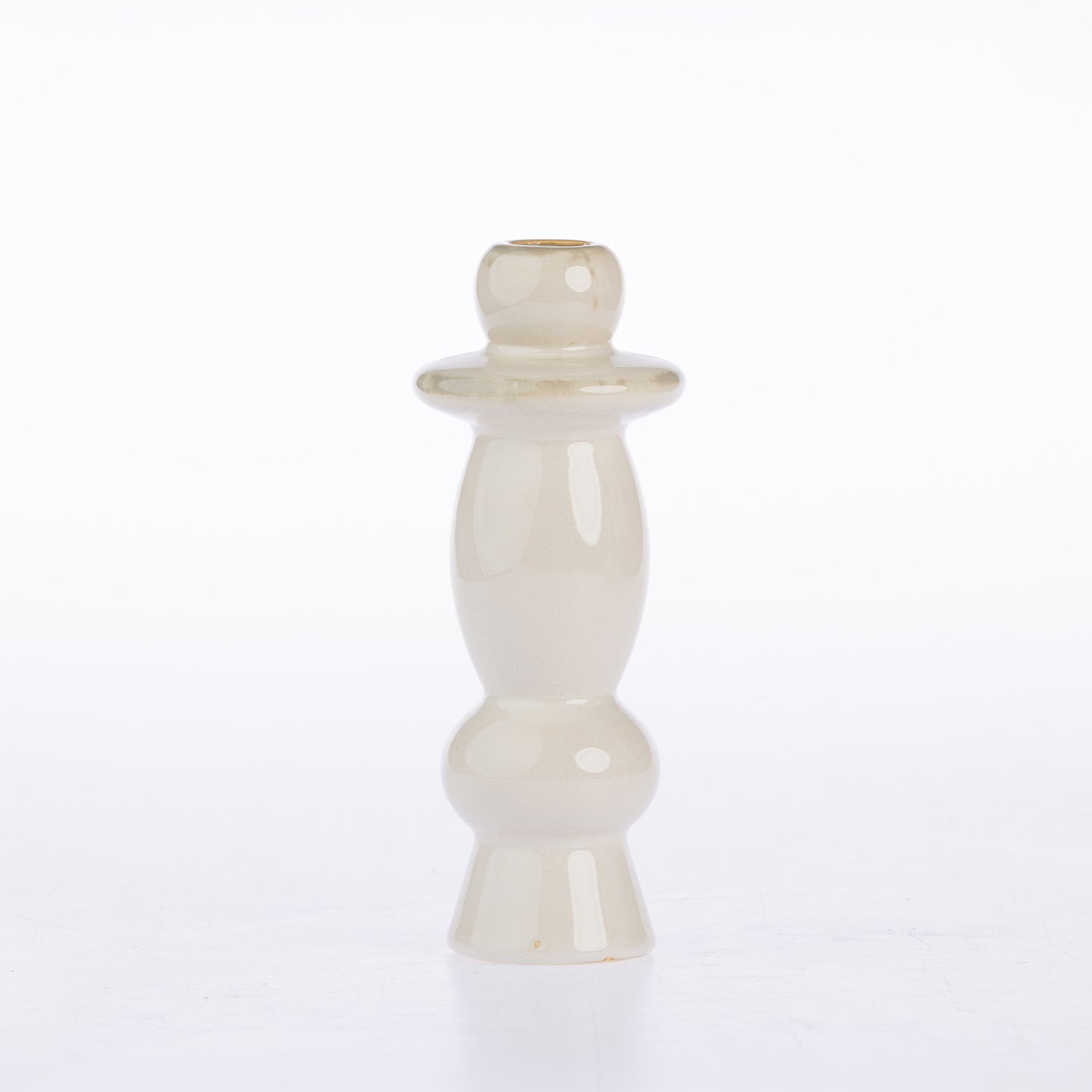 A small glossy ceramic candle holder with a bulbous, tiered design in a warm cream or off-white glaze, set against a plain white background.