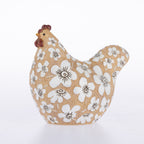 A decorative ceramic chicken figurine with a textured tan body, white floral pattern, and brown comb, shown on a clean white background.
