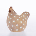 A ceramic chicken figurine with a warm tan body, white polka dots, and a dark brown comb, shown on a plain white background.