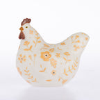 A ceramic decorative chicken figurine with a textured off-white body, decorated with orange floral patterns and a brown comb and wattle, set against a plain white background.