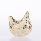 A decorative ceramic chicken figurine with a glossy white glaze and raised gold floral patterns, set against a seamless white background.