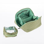 Open light green quilted toiletry bag showing internal compartments and a matching removable clear pouch.