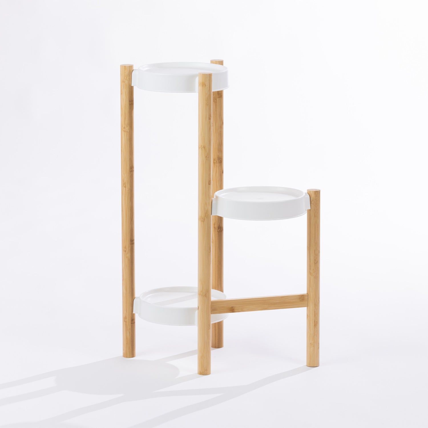A modern tiered planter stand with crisp white shelves and natural bamboo legs offers a stylish way to display multiple indoor plants while maximising vertical space.