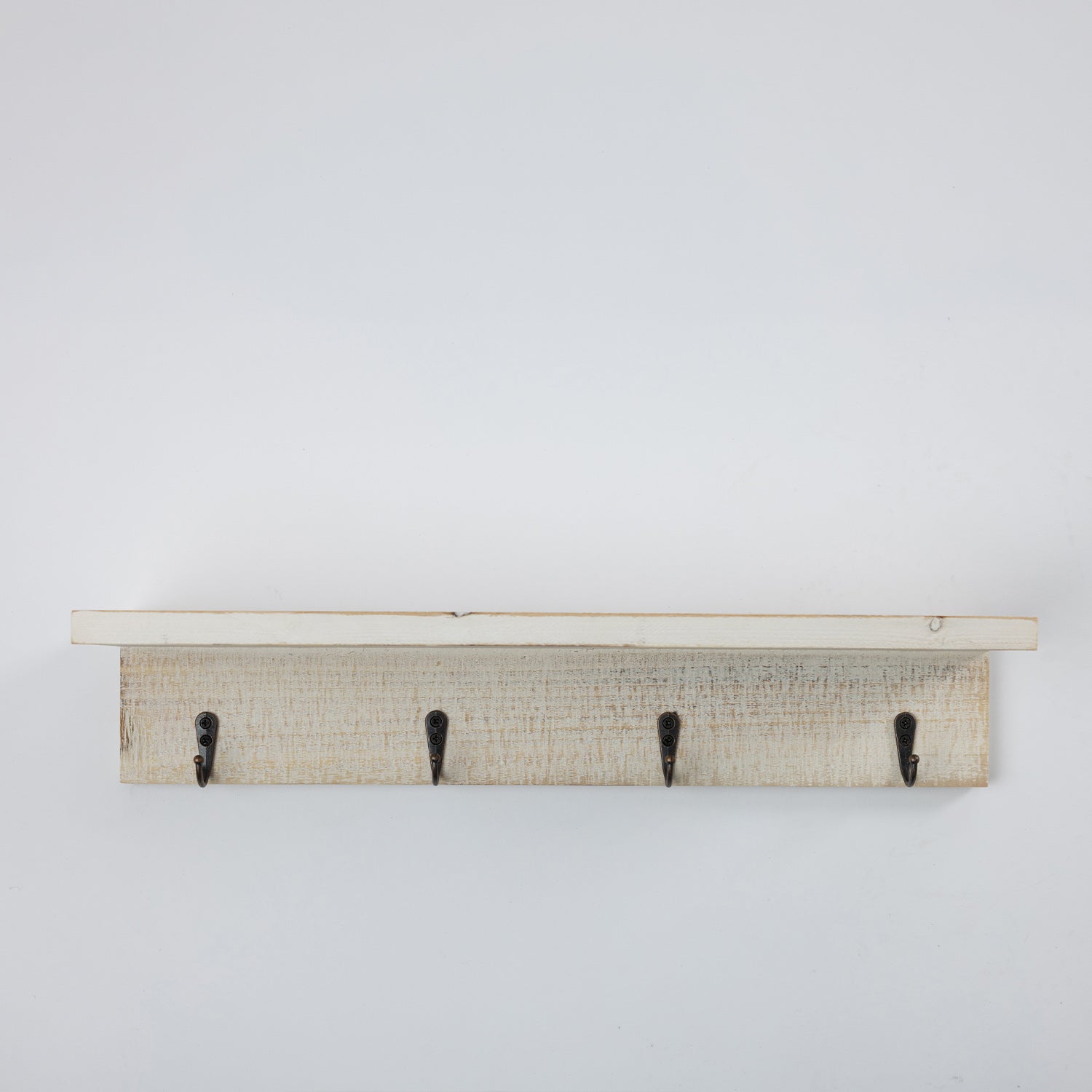 A rustic white-washed wooden wall hook rack with four black metal hooks, shown against a plain white background.
