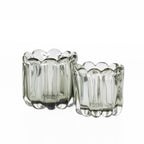 Two smoked grey hand-blown glass bud vases in coordinating sizes, each featuring a scalloped rim and ribbed curved design, displayed on a white background.
