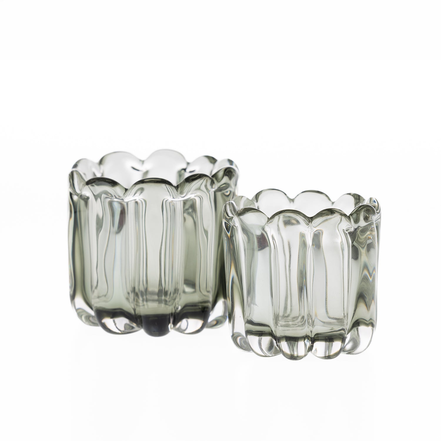 Two smoked grey hand-blown glass bud vases in coordinating sizes, each featuring a scalloped rim and ribbed curved design, displayed on a white background.
