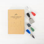 Gather 4 Piece Cheese Knife Set Multi-Coloured featuring stainless steel cheese utensils with red, black, green and blue handles beside the gift packaging.